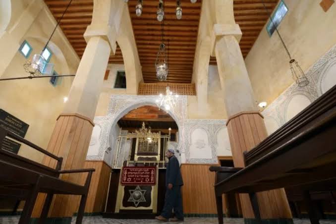 The interior of Slat Al Fassiyine Synagogue in Fes — one of the oldest synagogues in Morocco, its tall whitewashed columns, cedar ceiling and stone floor create a space of quiet grandeur that speaks of centuries of continuous Jewish religious life in the city